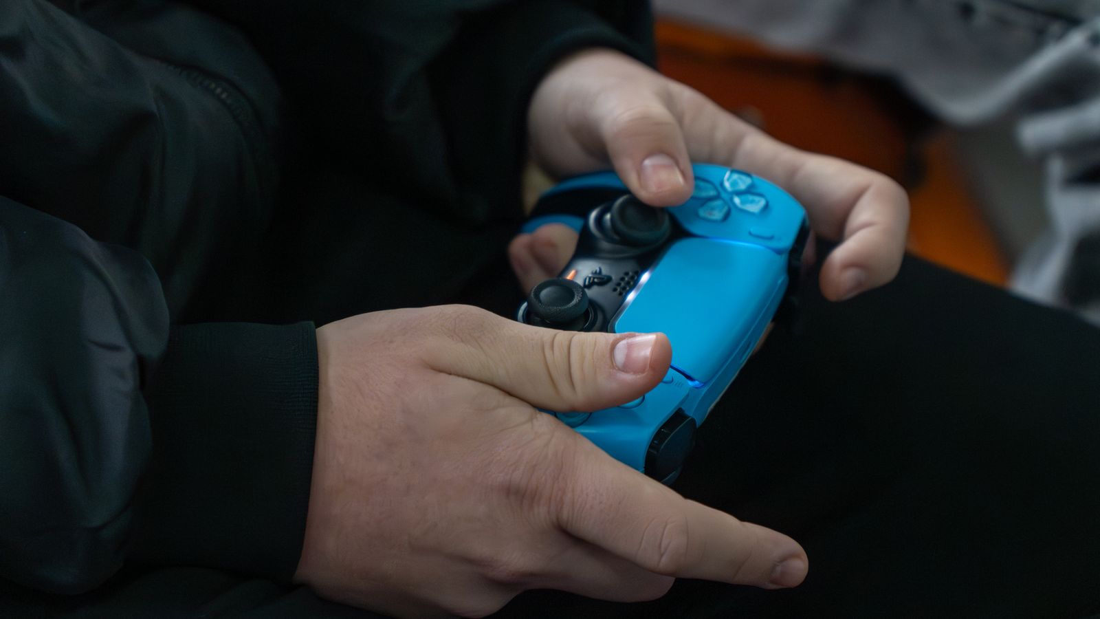 Jogador segurando um controle de PlayStation 5 durante uma partida do campeonato