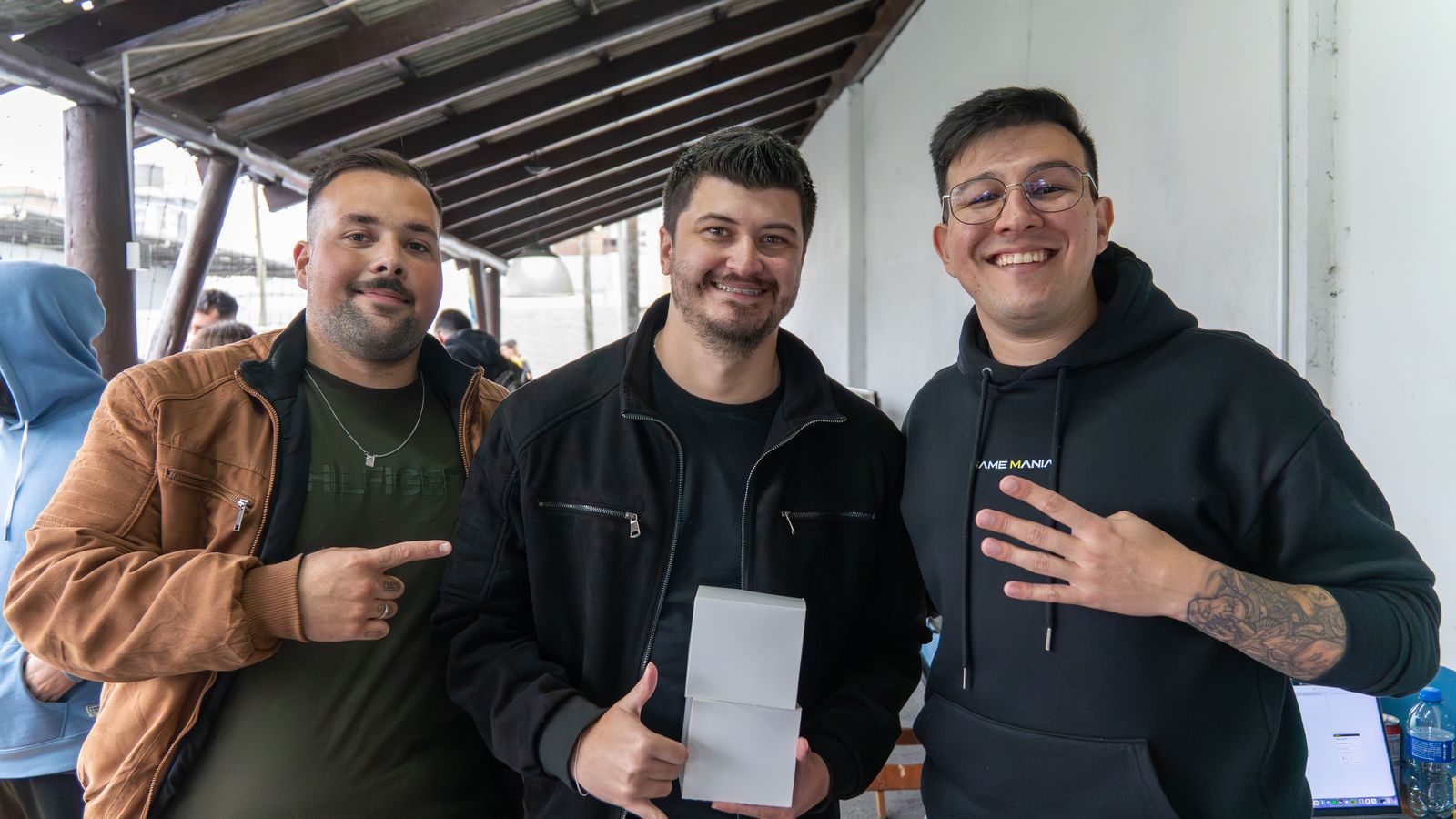 Participante recebendo a premiação ao lado da equipe Game Mania