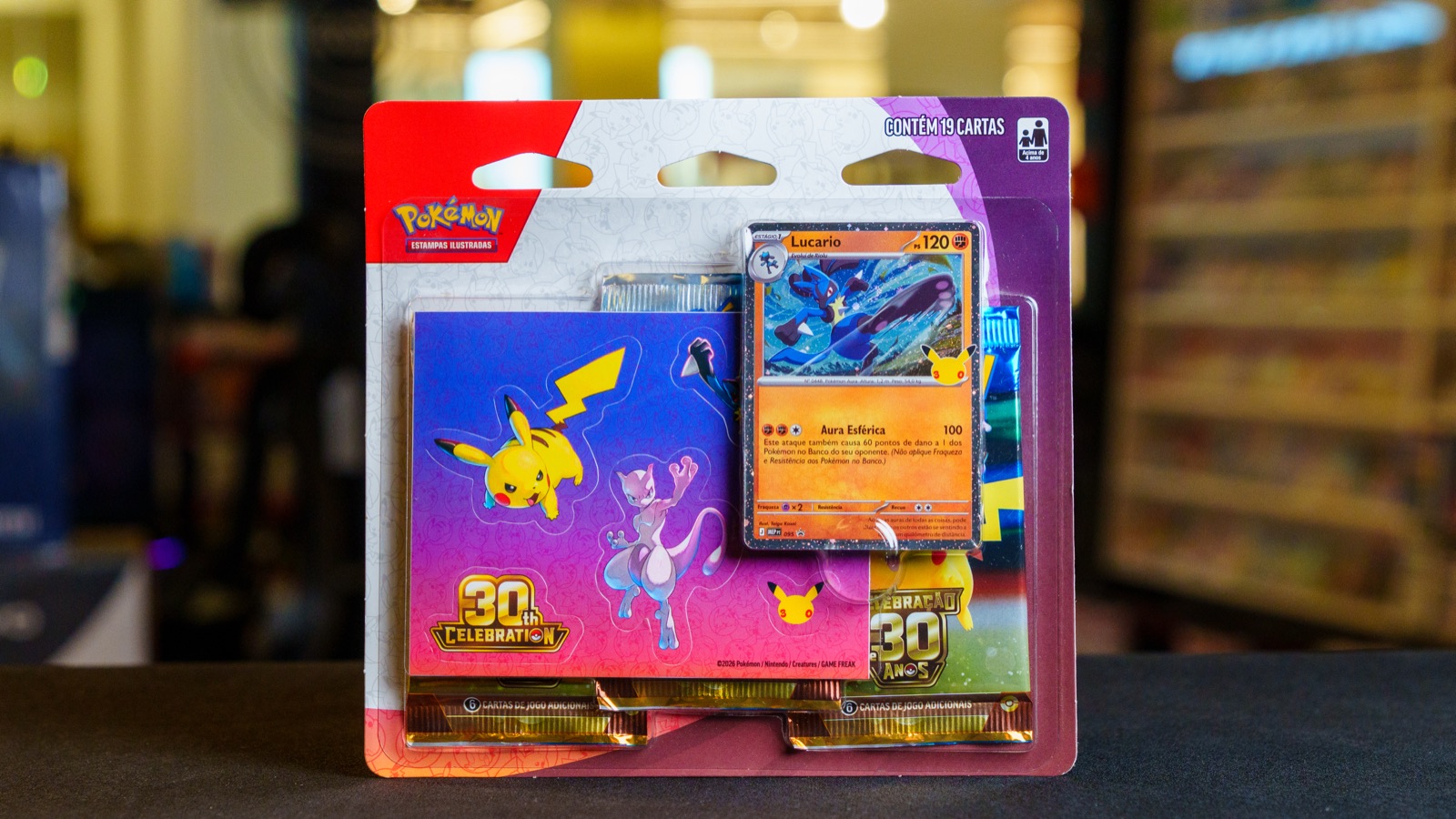 Blister triplo da Celebração de 30 Anos de Pokémon com carta do Lucario e adesivos do Pikachu e do Mewtwo