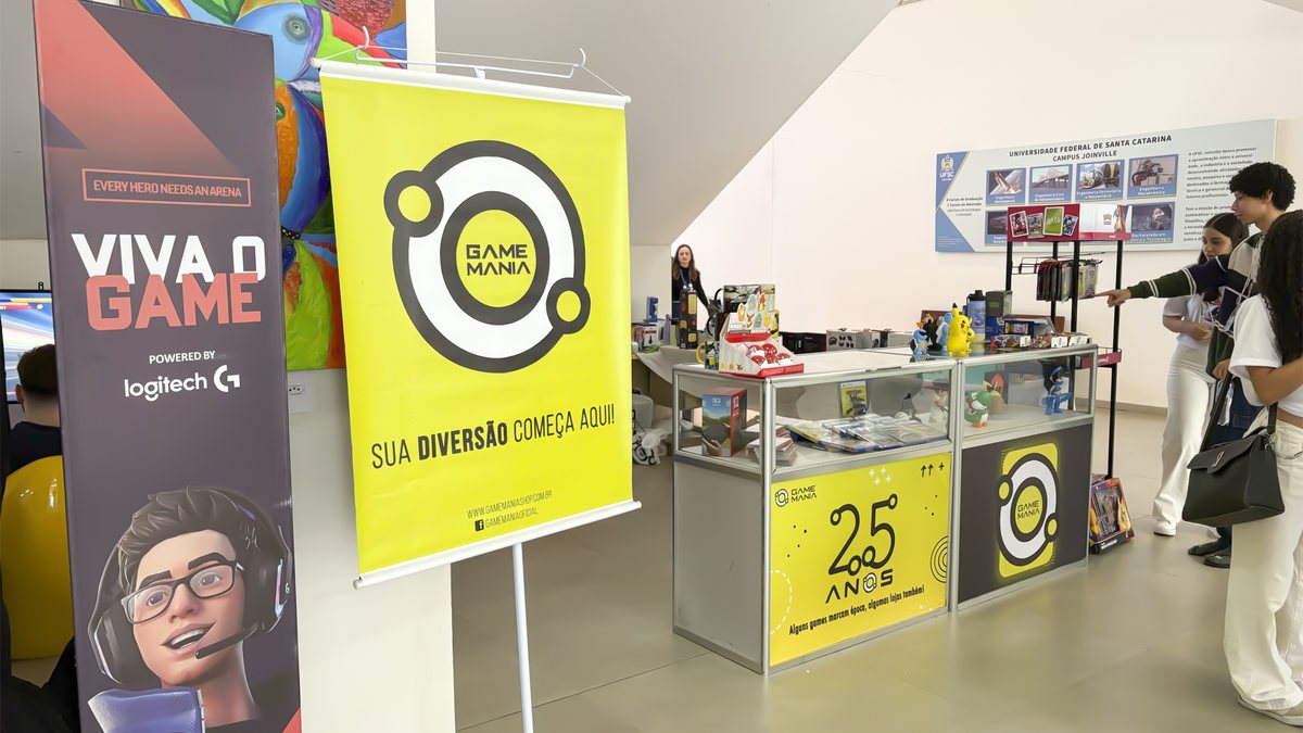 Banner da ativação Viva o Game, parceria entre Arena Hero Base e Logitech G, ao lado do estande da Game Mania na Feira de Cursos da UFSC Joinville