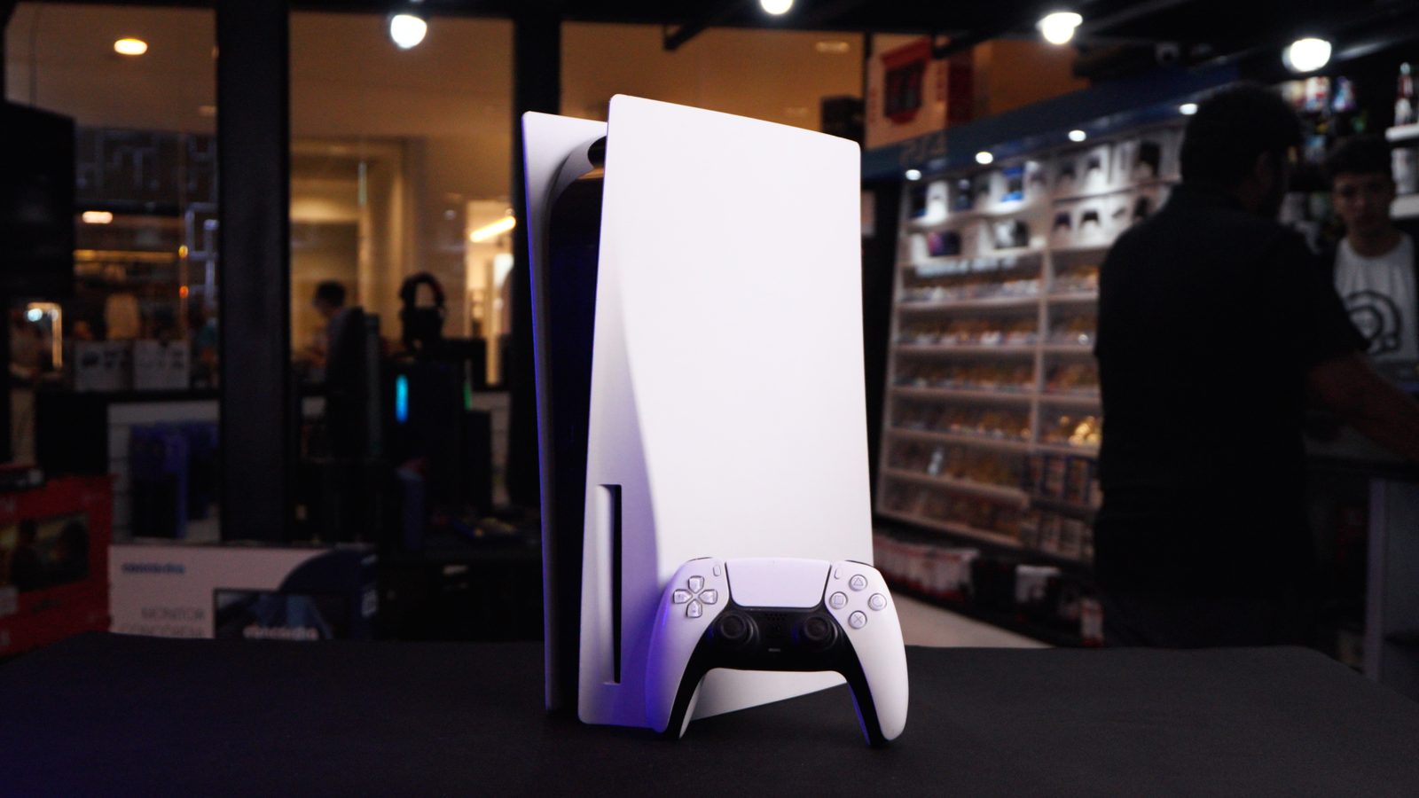 PlayStation 5 novo, com controle DualSense, exposto no balcão de uma loja Game Mania