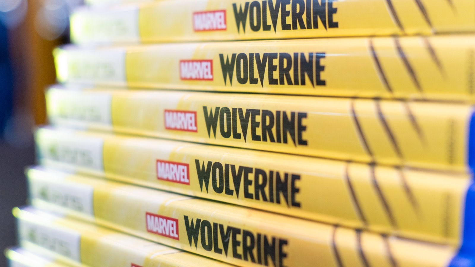 Pilha de cópias de Marvel's Wolverine para PlayStation 5, vista de perto pelas lombadas das caixas, em uma loja Game Mania