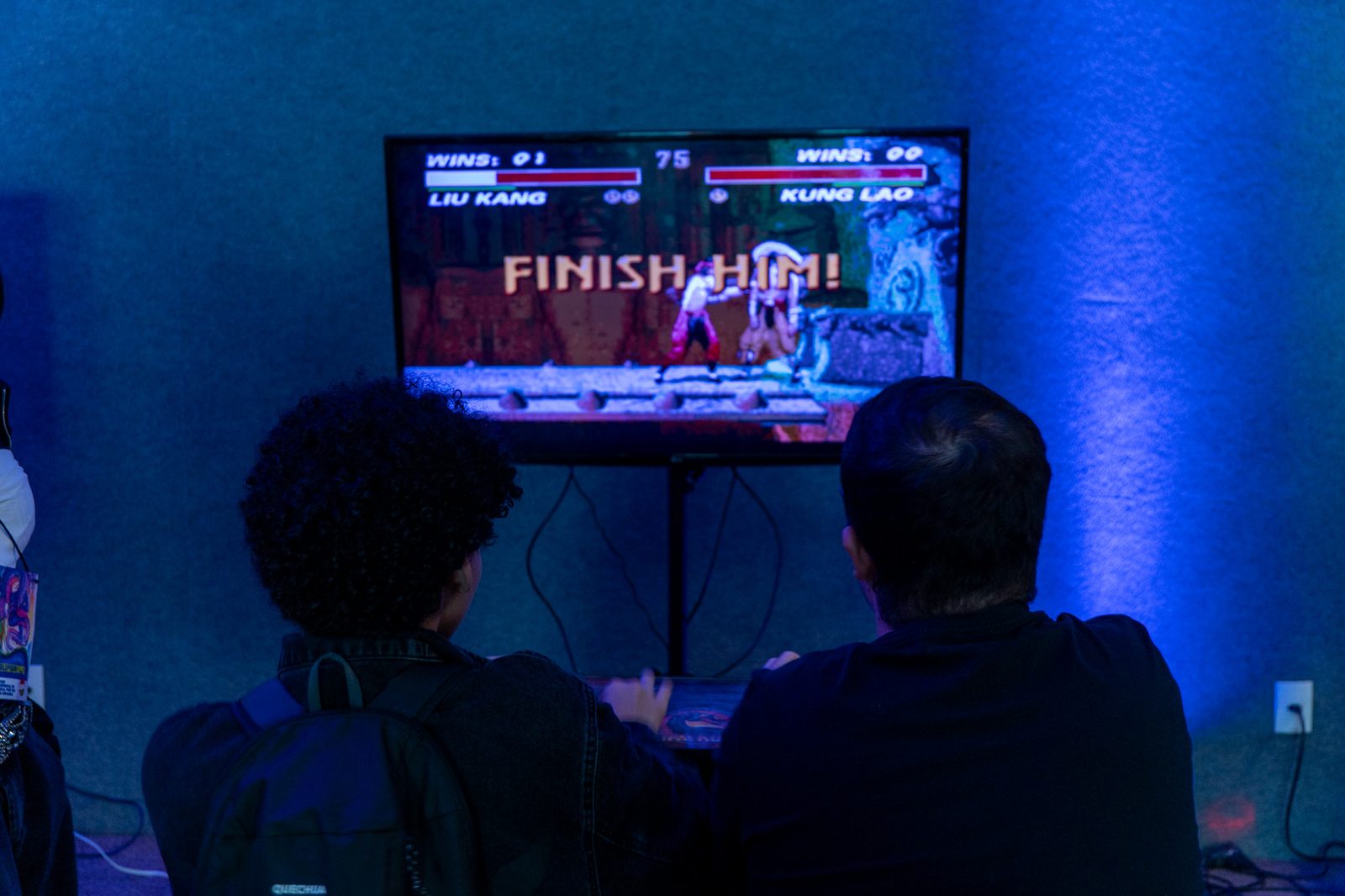 Dupla jogando Mortal Kombat em fliperama retrô